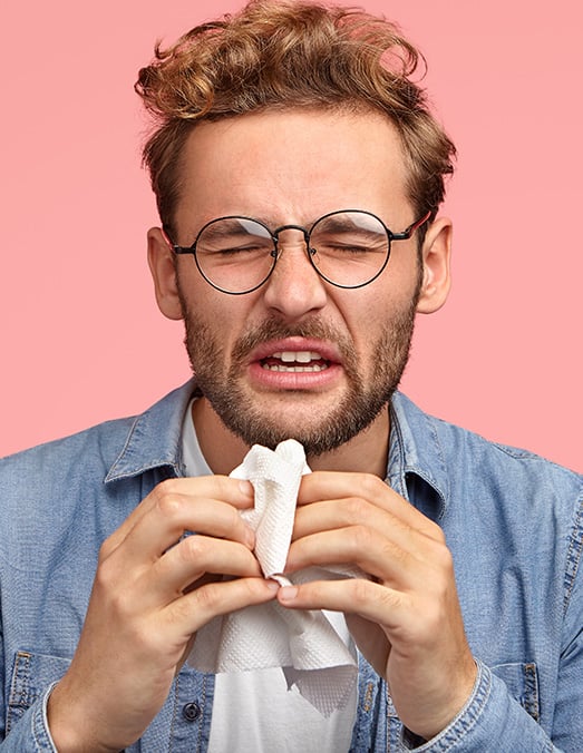 a person sneezing from allergy