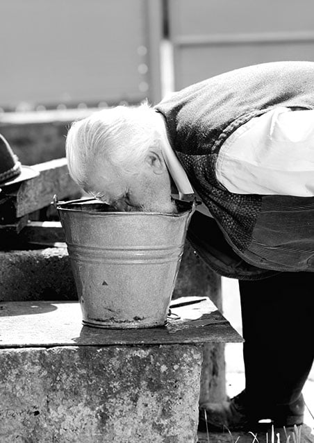 A person drinking out of a bucket
