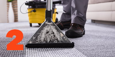 A custodian vacuuming the carpet