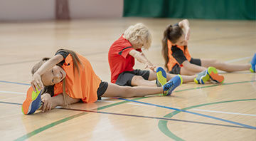 Kids stretching on a gym floor