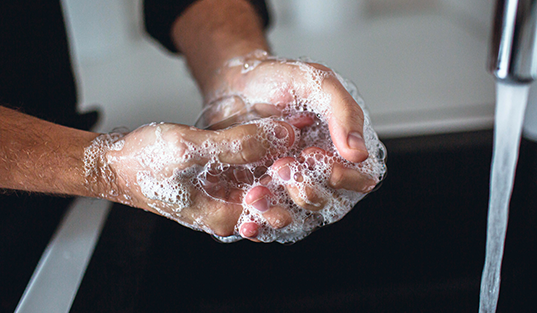 a person washing hands using soap - hand hygiene