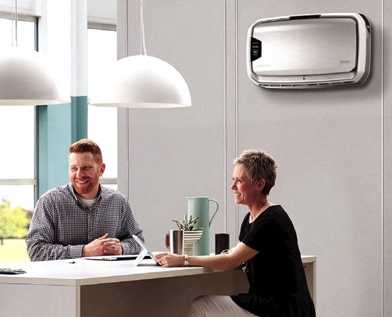 people talking to each other in an office showing wall mounted air purifier