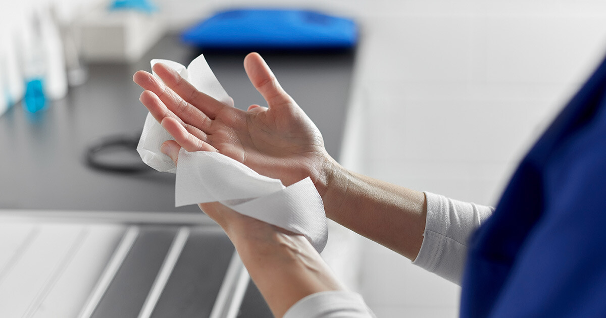 sanitizing hands with disinfectant wipe