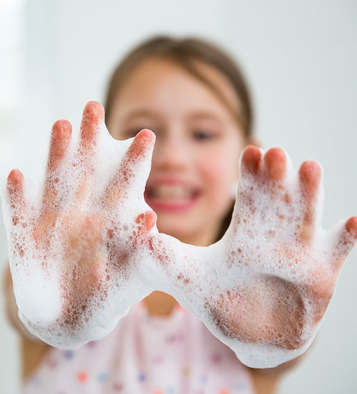 a kid holding out hands with soap on them