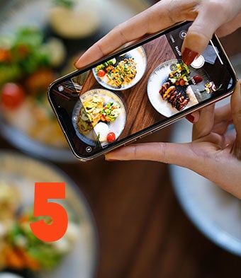 person taking photo of beautifully plated food at the restaurant for social media post