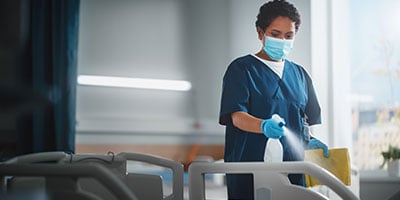 healthcare worker cleaning paitent beds