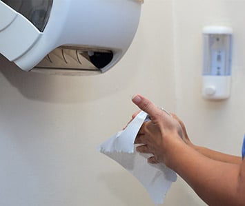 person using paper towel dispenser