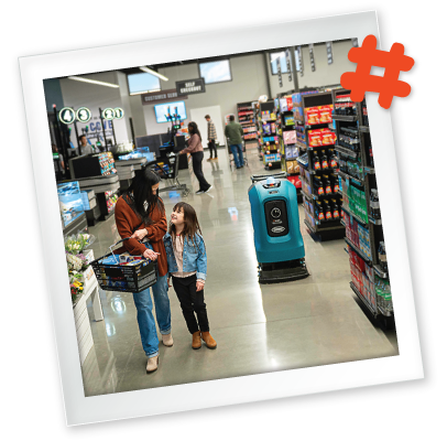 Grocery store with autonomous floor equipment in action while customers are shopping - automation