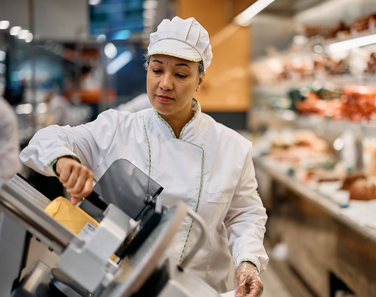 supermarket clerk using meat slicer