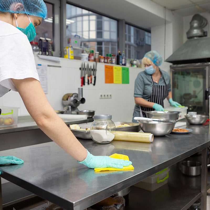 school kitchen staff disinfecting coutertops