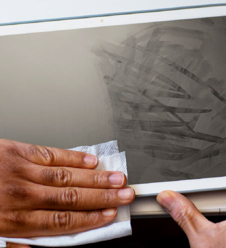 a person using Clorox Screen wipe to clean table monitor