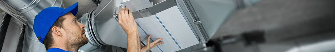 building maintenance working on cleaning and replacing air filter on the ventilation system - IAQ