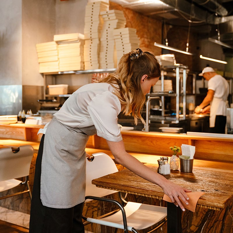 a clean restaurant with staff cleaning the table