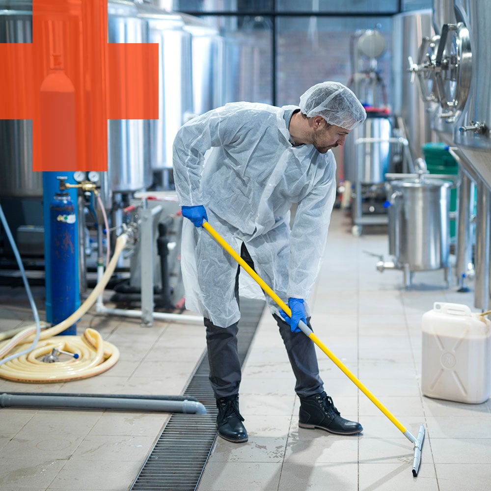 a person scrubbing floor at the food processing plant