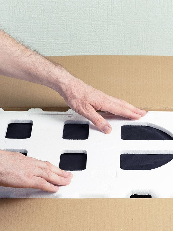 a person using foam sheet to protect shipment