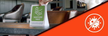 a table with sanitized sign on with blocking germs icon