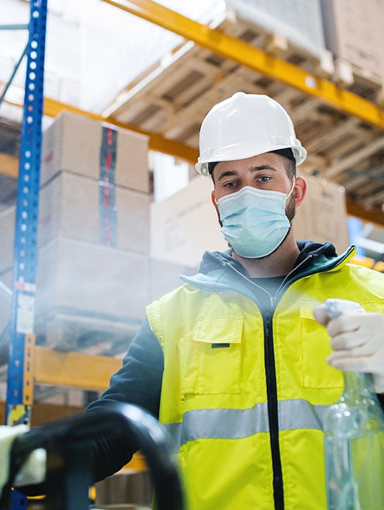 warehouse worker surface disinfecting using spray