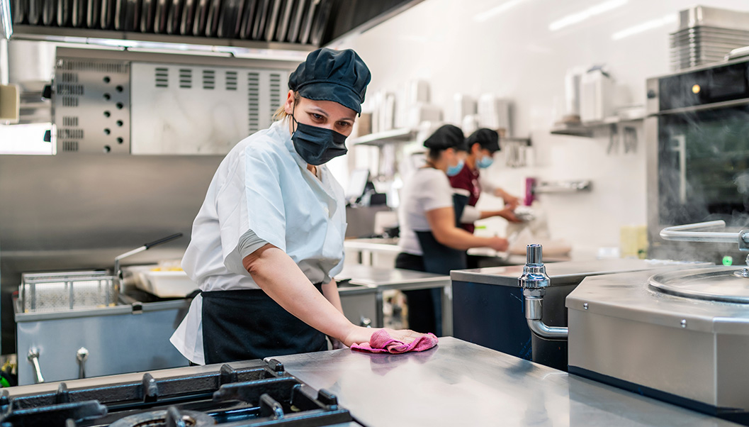 kitchen staff wiping off the countertop for prepping