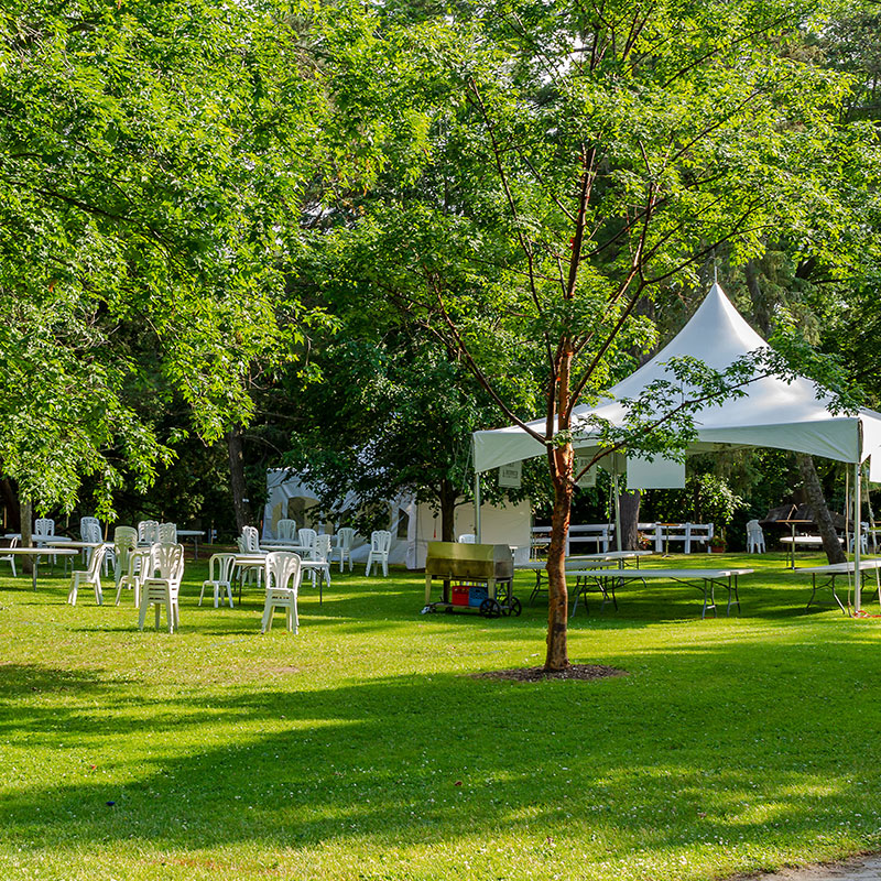 outdoor event with tent, table and chair setup for catering