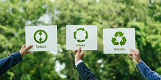 reduce environmental impact - businessmen holding reduce, reuse and recycle signs